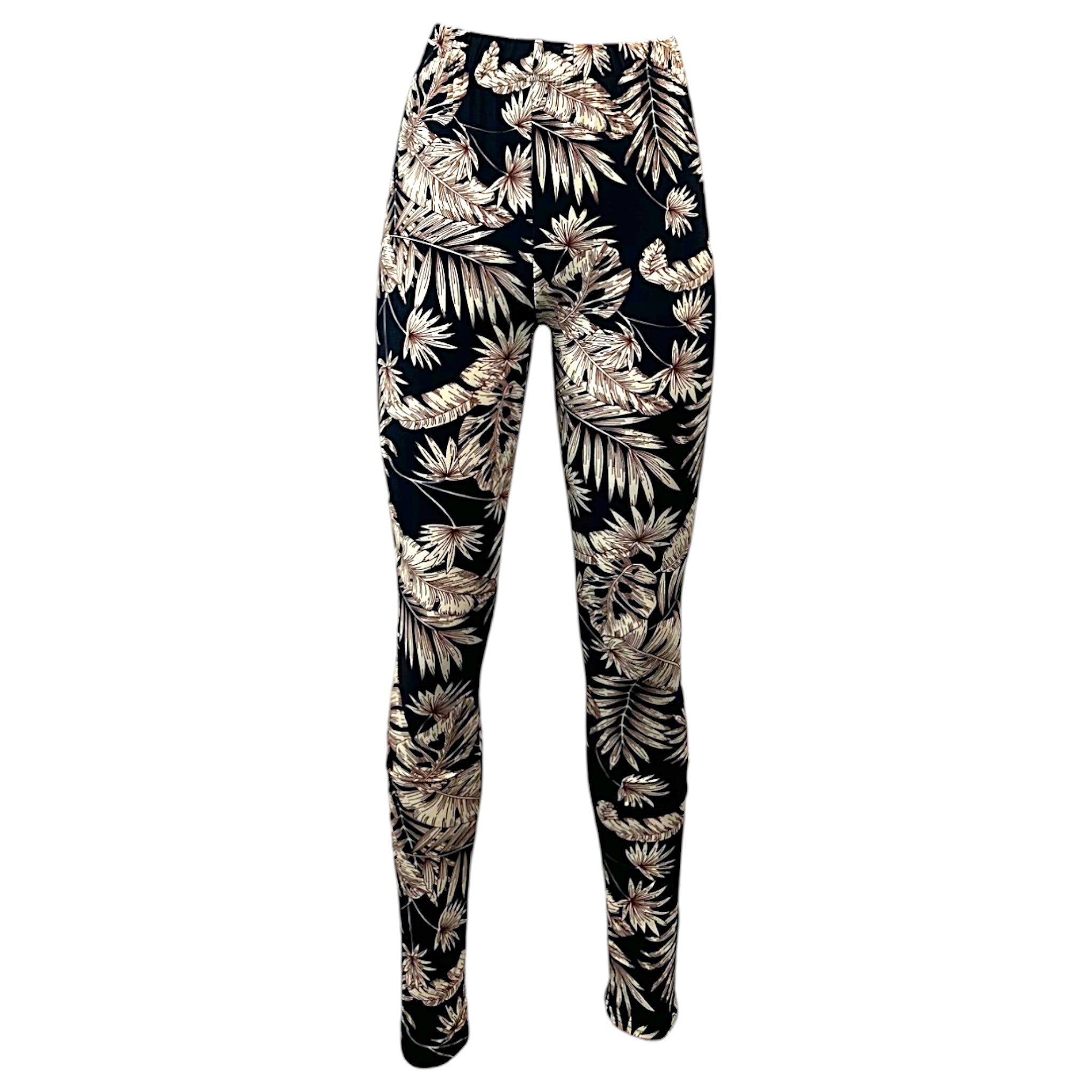 Women's black leggings with beige tropical leaf print, full-length stretch fit.